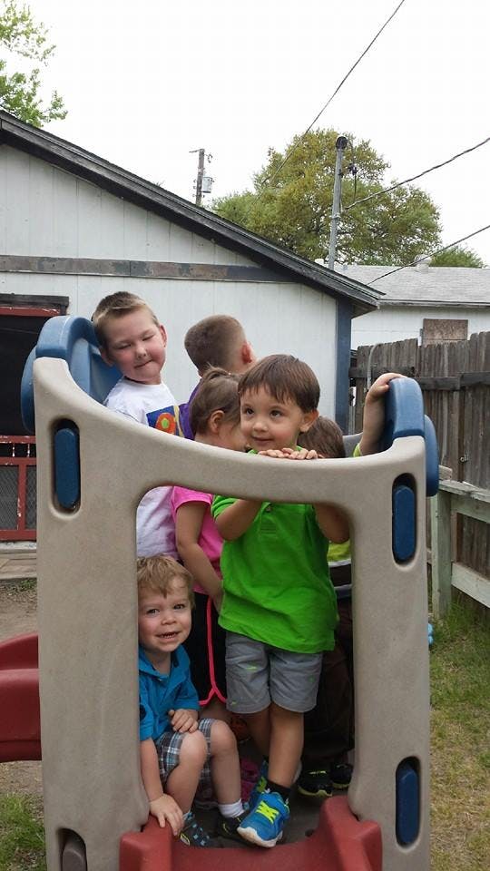 Multiple children playing on a plastic slide structure