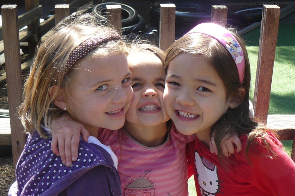 Three children with arms around each other