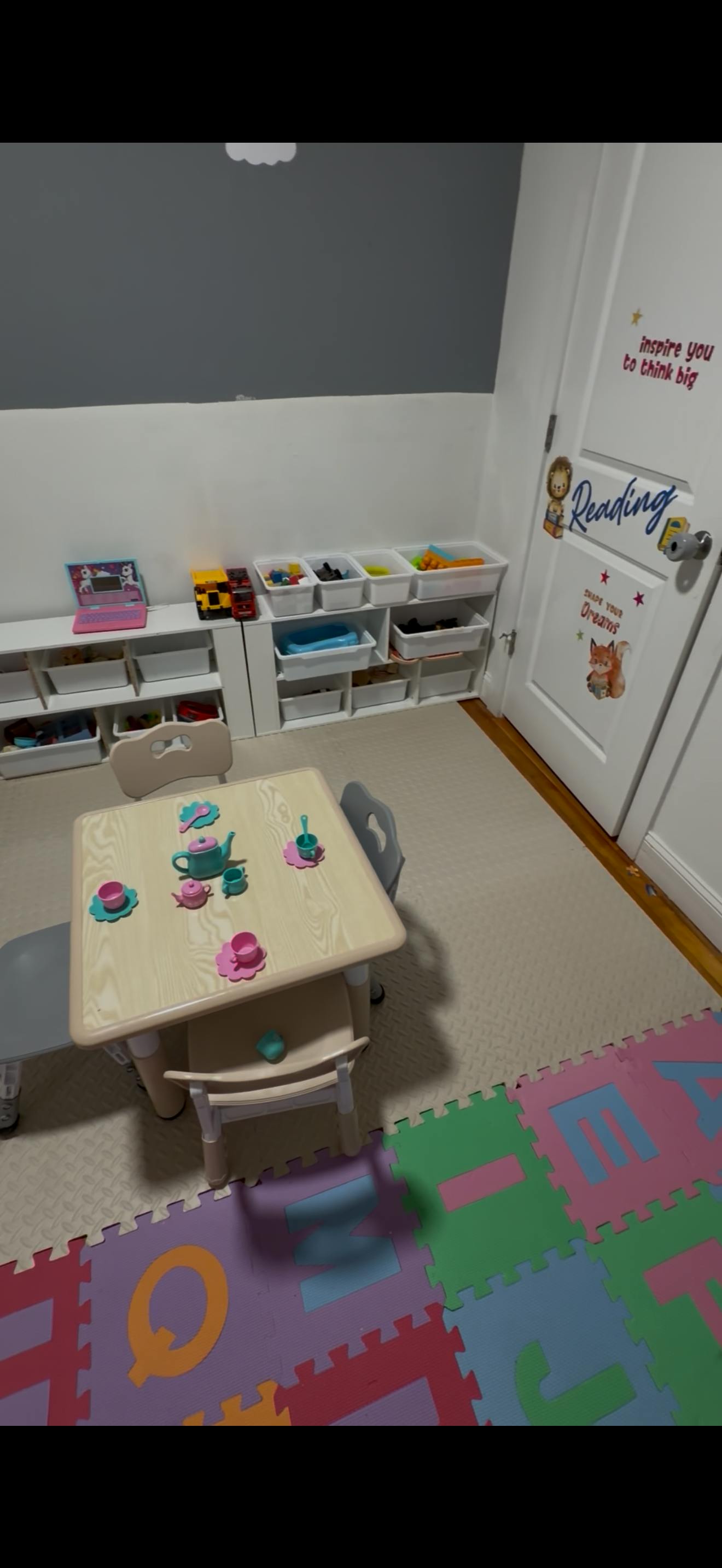 Childs table with tea set and storage shelves in a playroom
