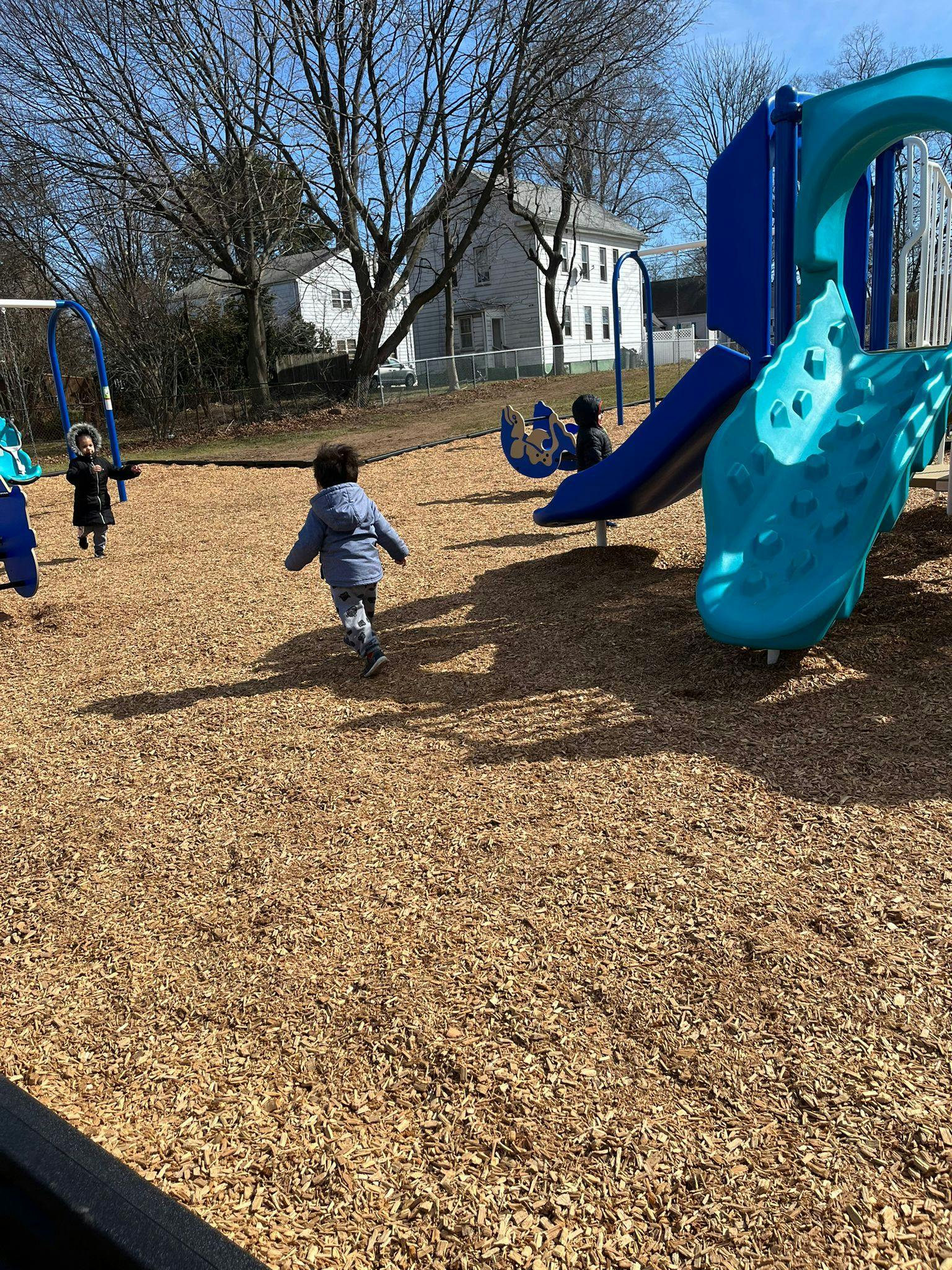 Children playing on a playground with swings and slides