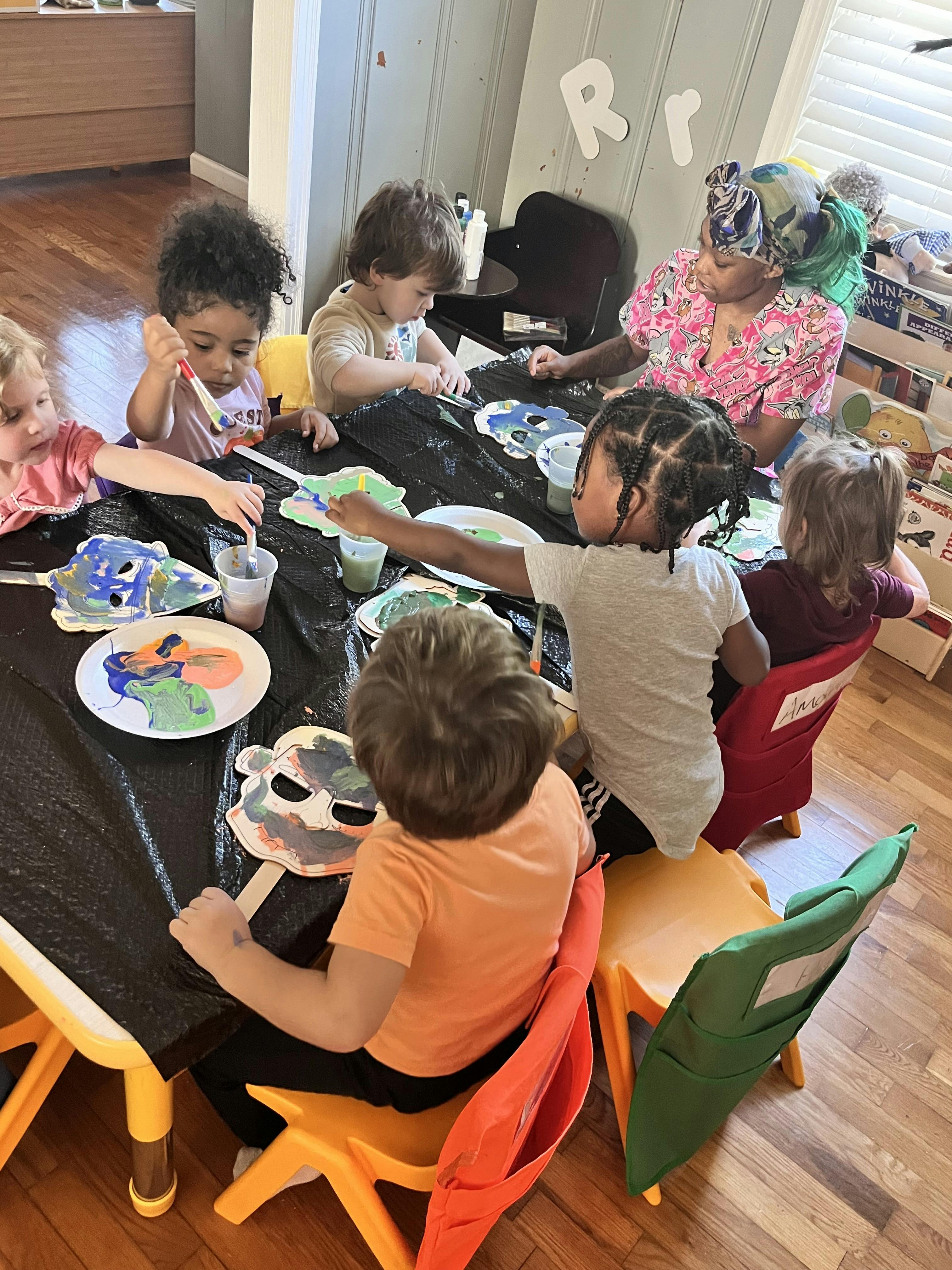 Adult and children painting at a table