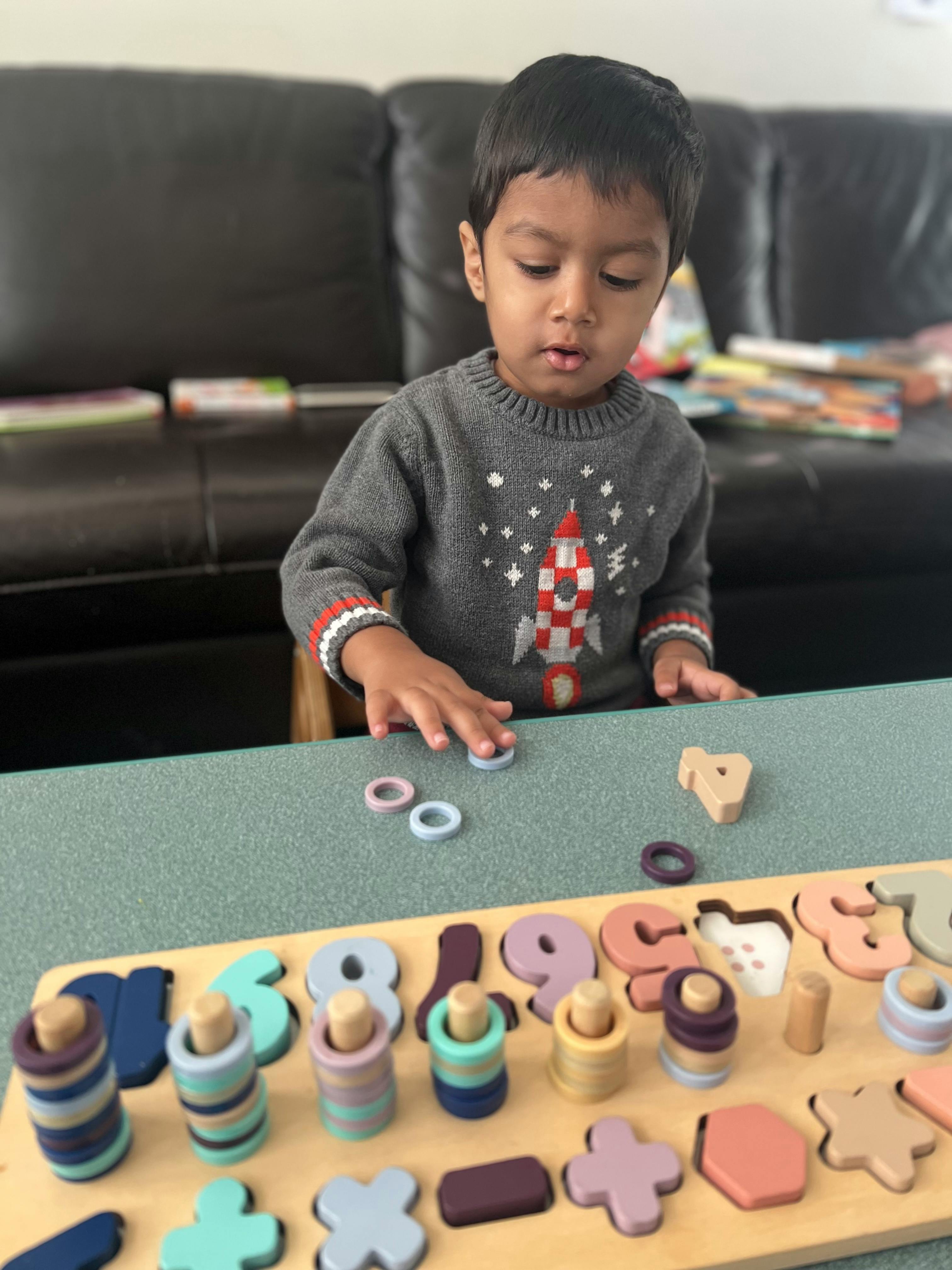 Child playing with a wooden number and shape puzzle