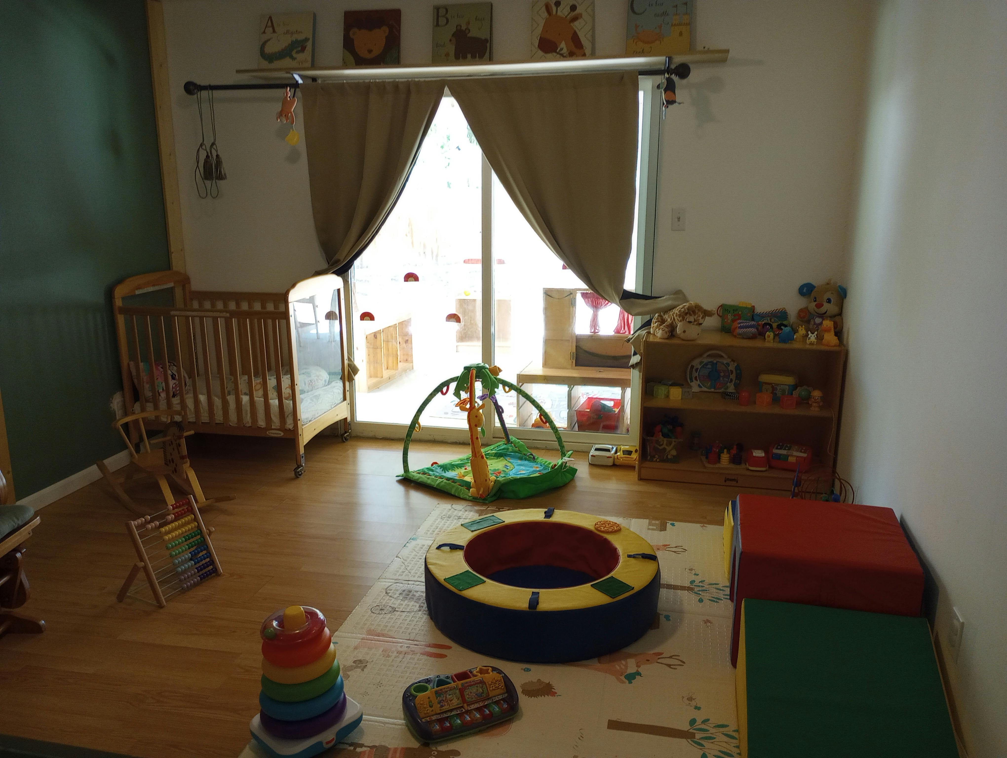 Nursery room with crib, play mat, and toys
