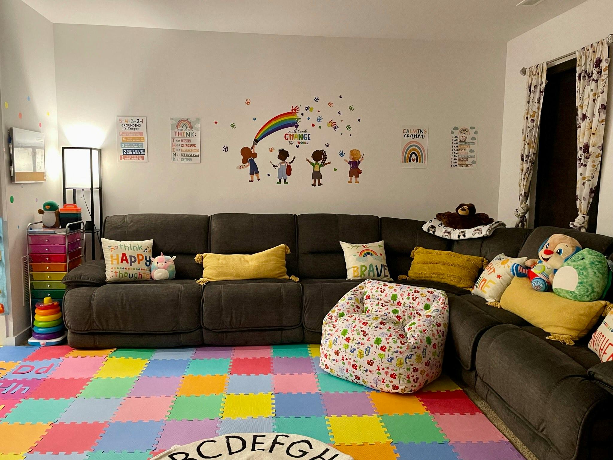 Living room with a large sectional sofa and colorful floor mats