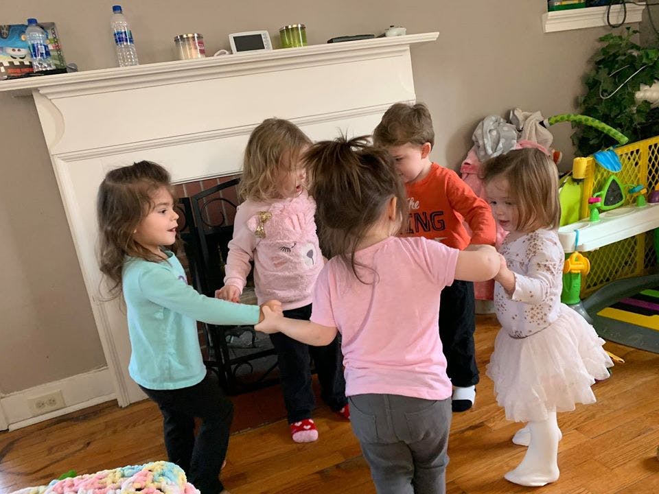 Five children holding hands in a circle