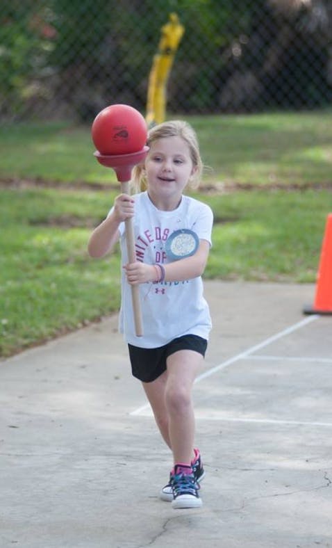 Child holding a red ball on a stick
