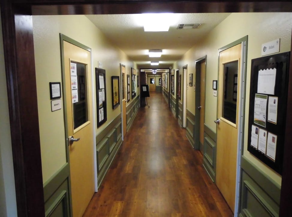Long hallway with wooden floor and doors on both sides