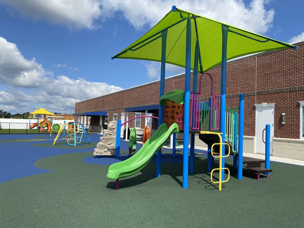 Playground with slides and climbing structures on a blue and green surface