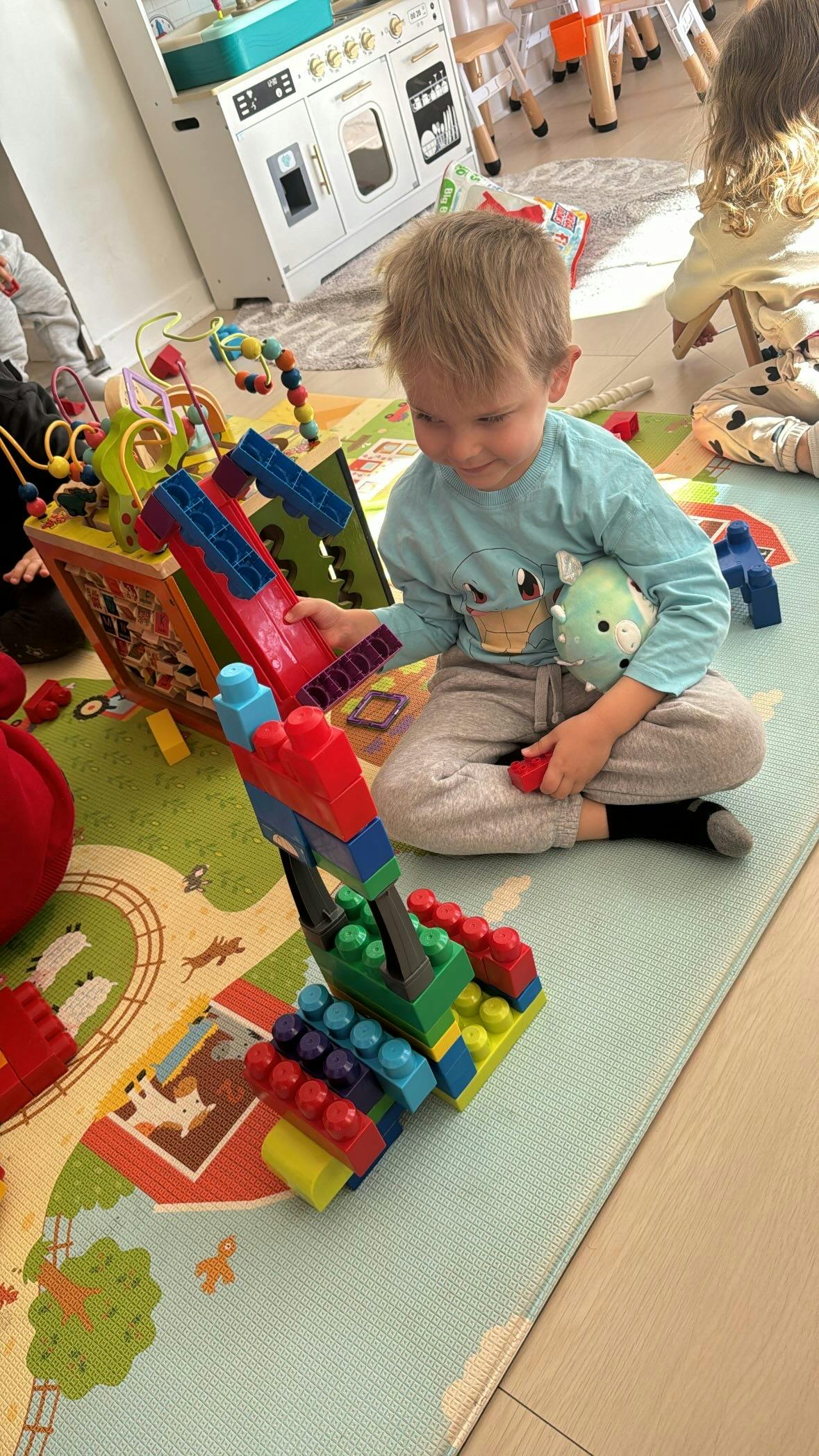 Child playing with colorful building blocks on a mat