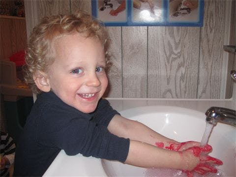 Child washing hands in a sink