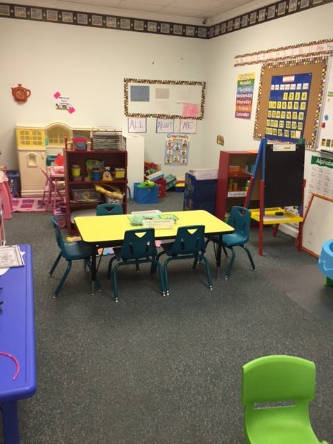 Classroom with small yellow table and blue chairs