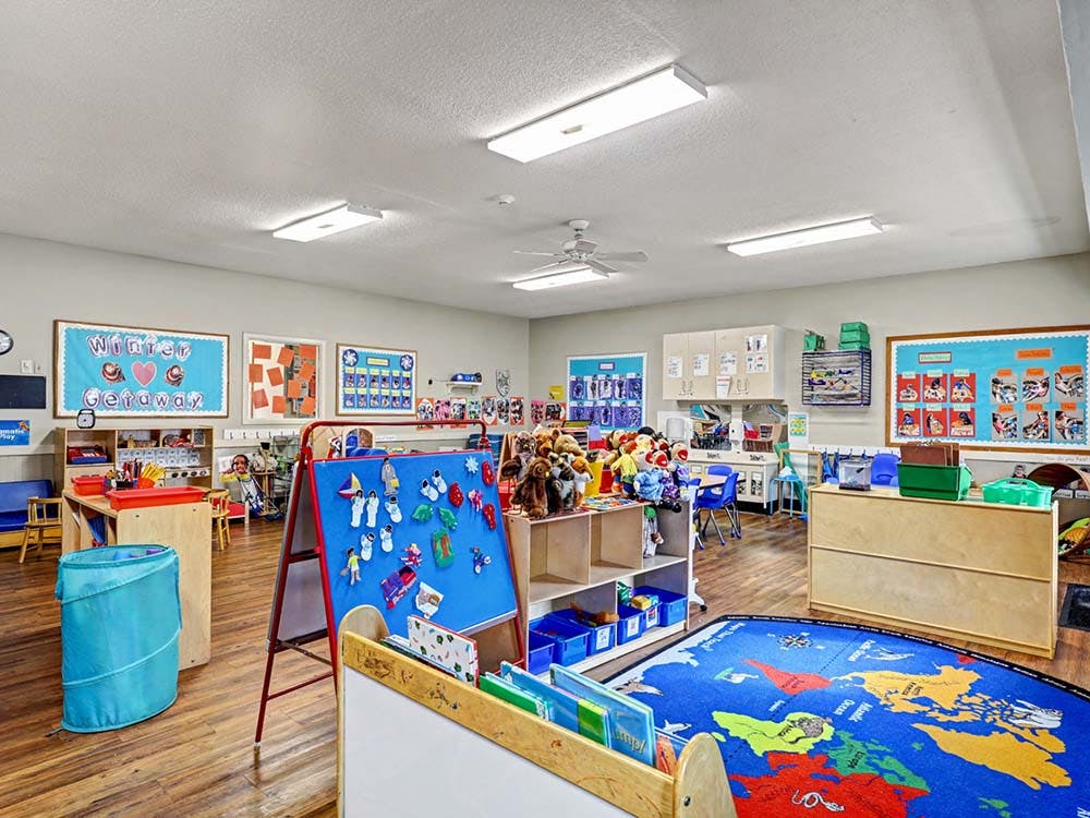 Children's playroom with a world map rug and an easel