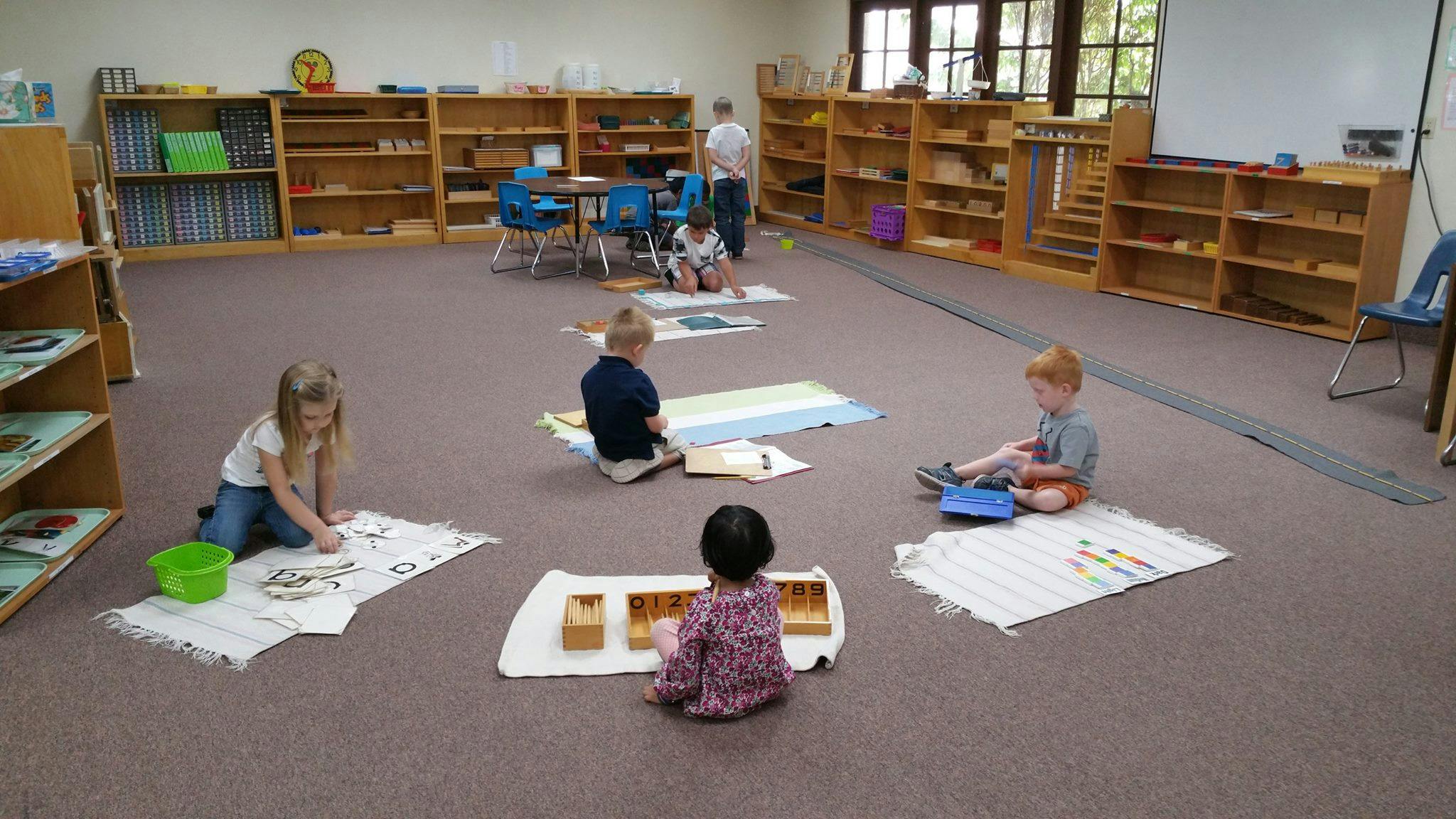 Children playing on floor mats in a classroom