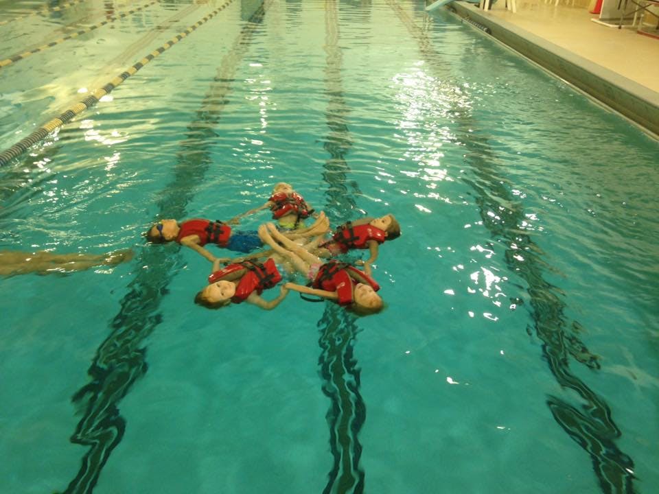 Children in life vests floating in a pool