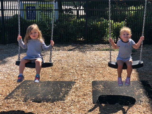Two children on swings at a playground
