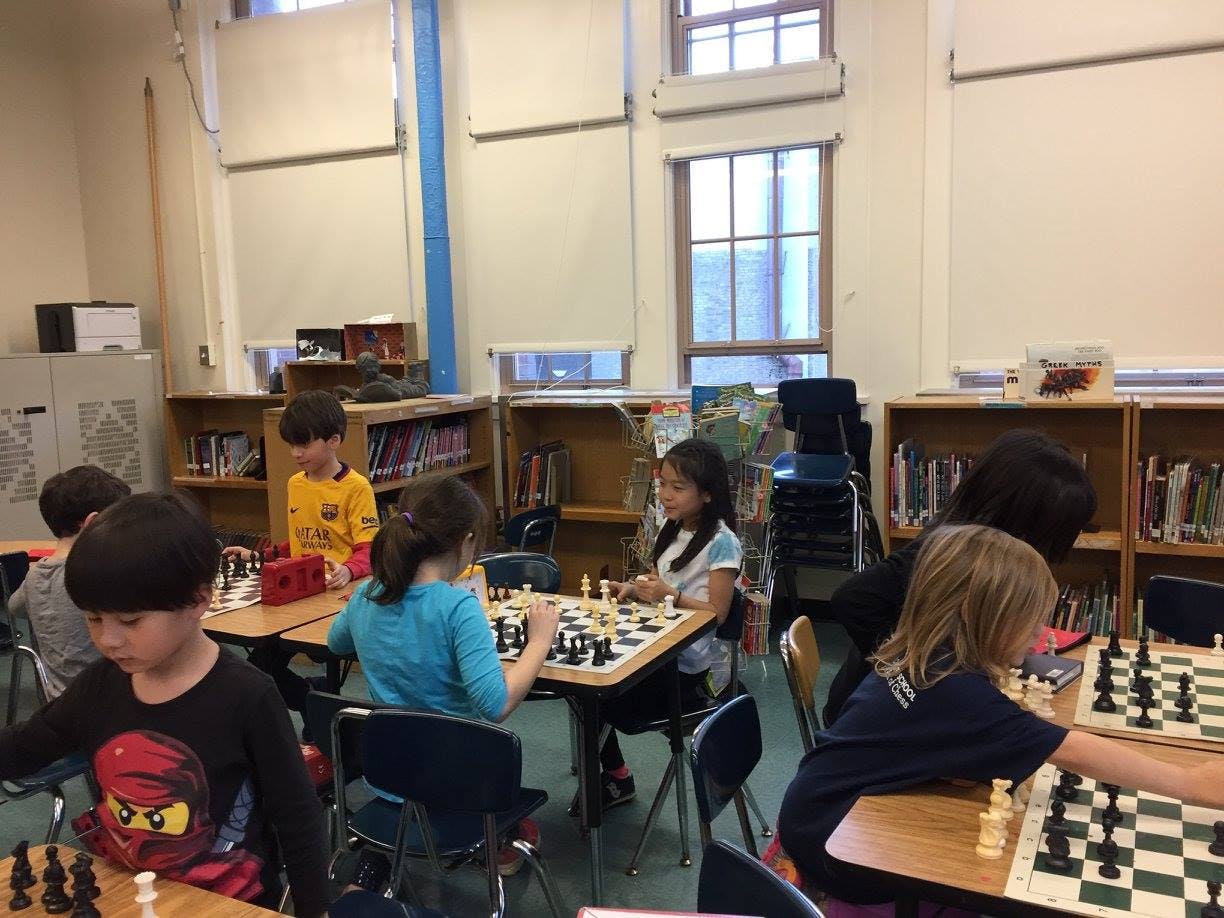 Children playing chess in a classroom