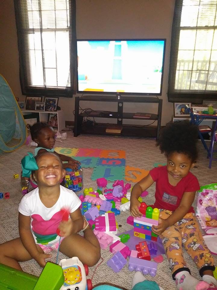 Three children playing with toys on the floor