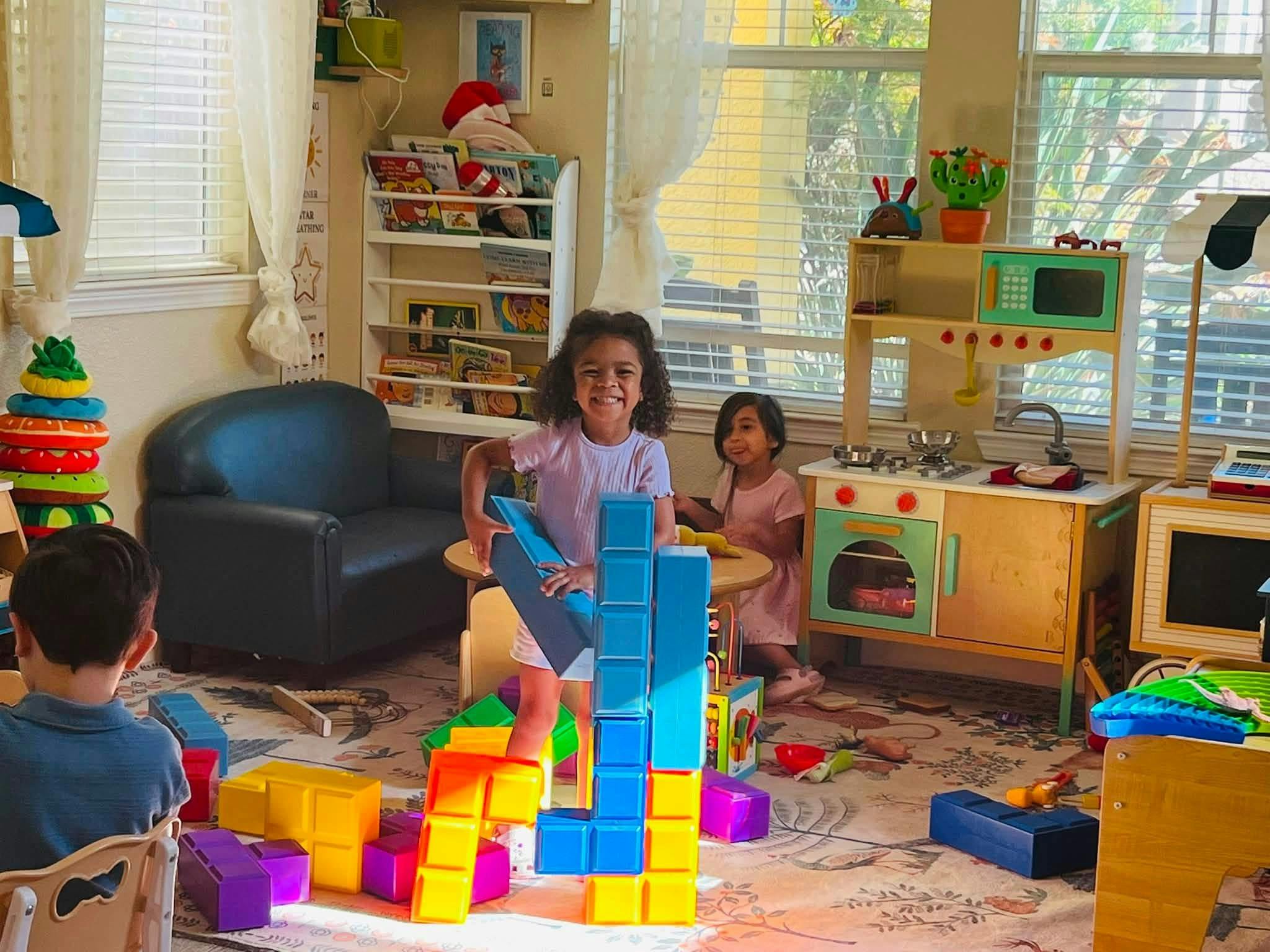 Children playing with plastic building blocks in a playroom