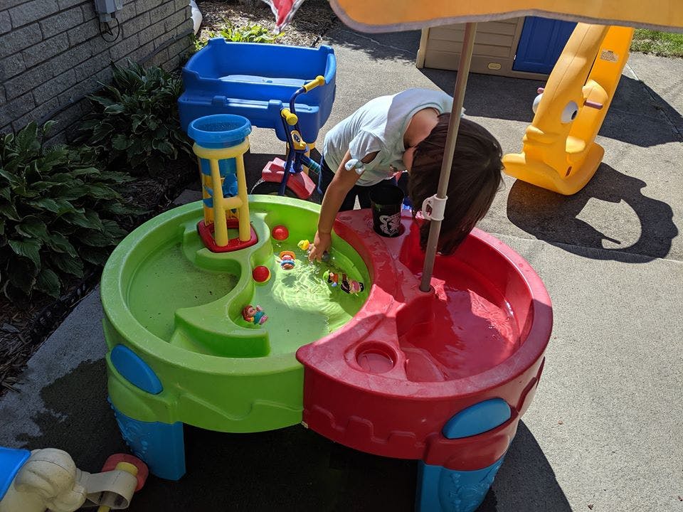 Child playing with a water table outdoors