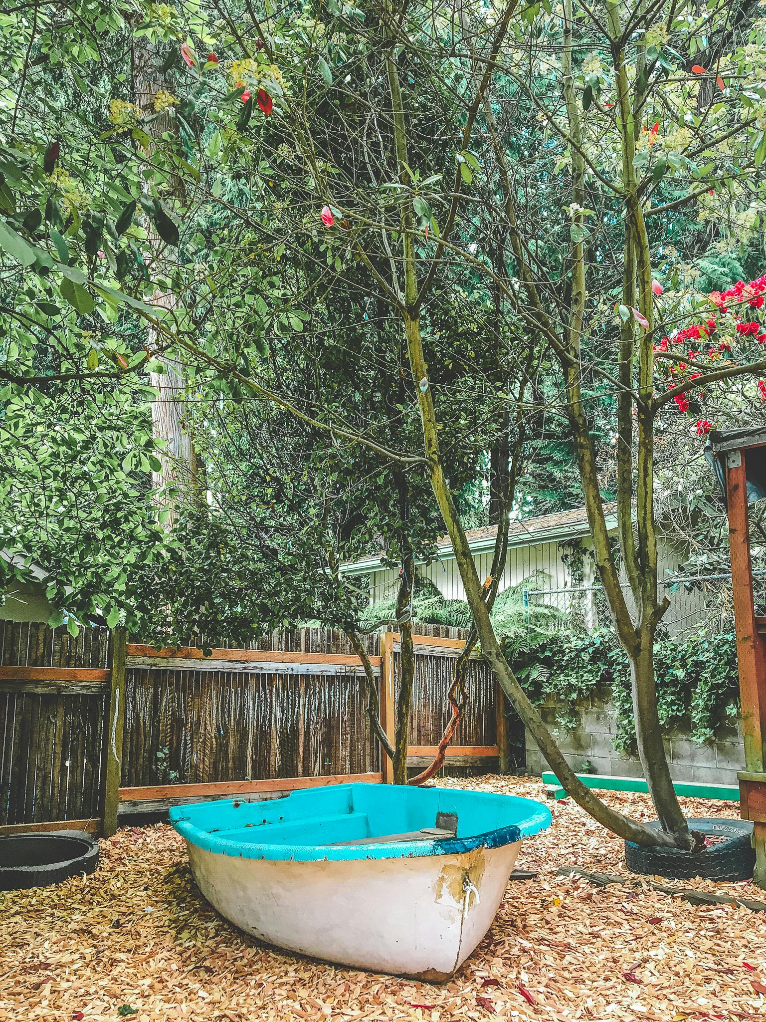 Small boat on wood chips under trees