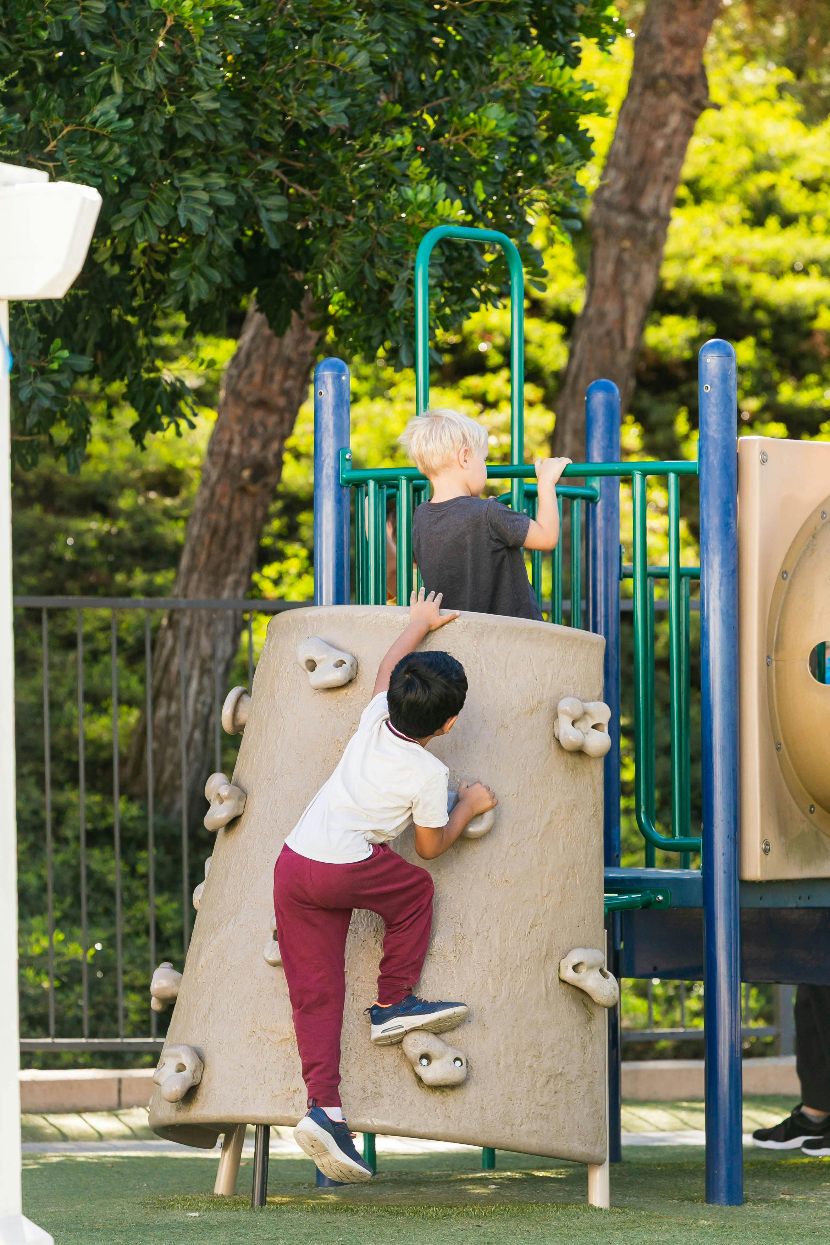 Two children playing on a climbing structure at a playground