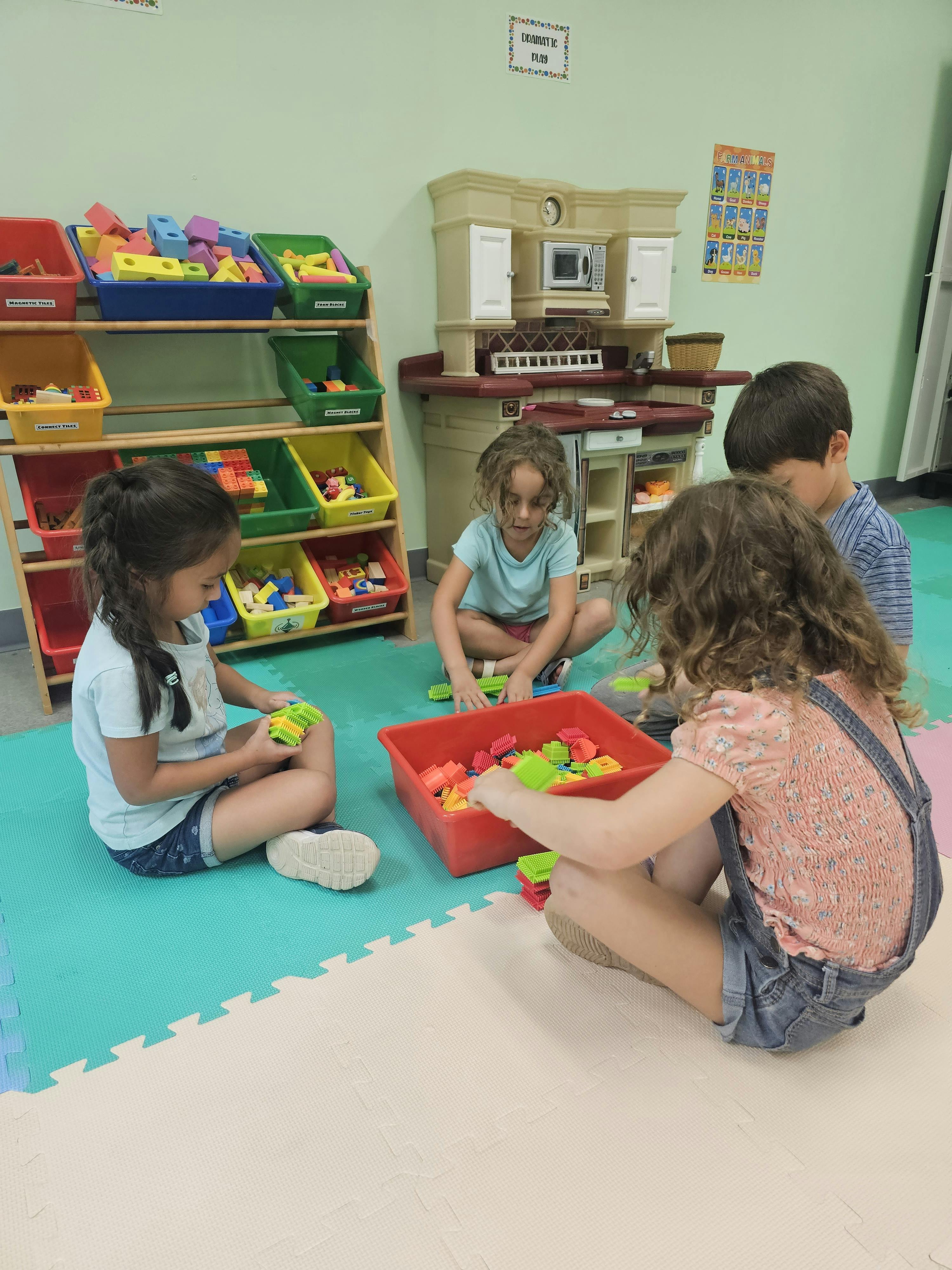 Children playing with toys on the floor in a classroom