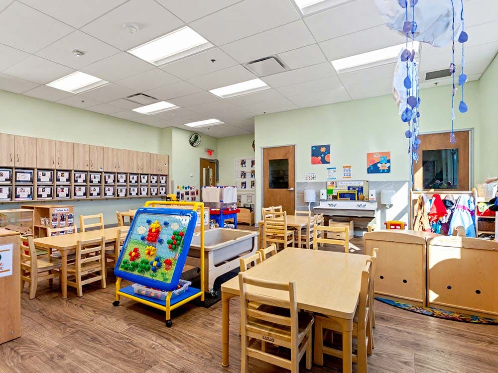 Classroom with wooden tables, chairs, and colorful learning activities