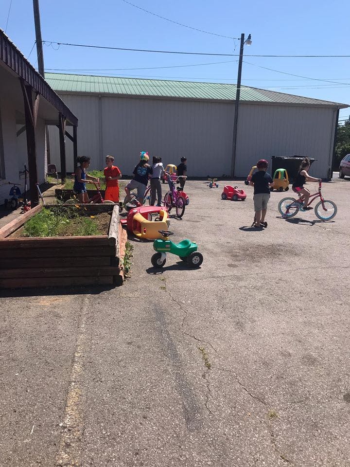 Children playing with bikes and toys outdoors