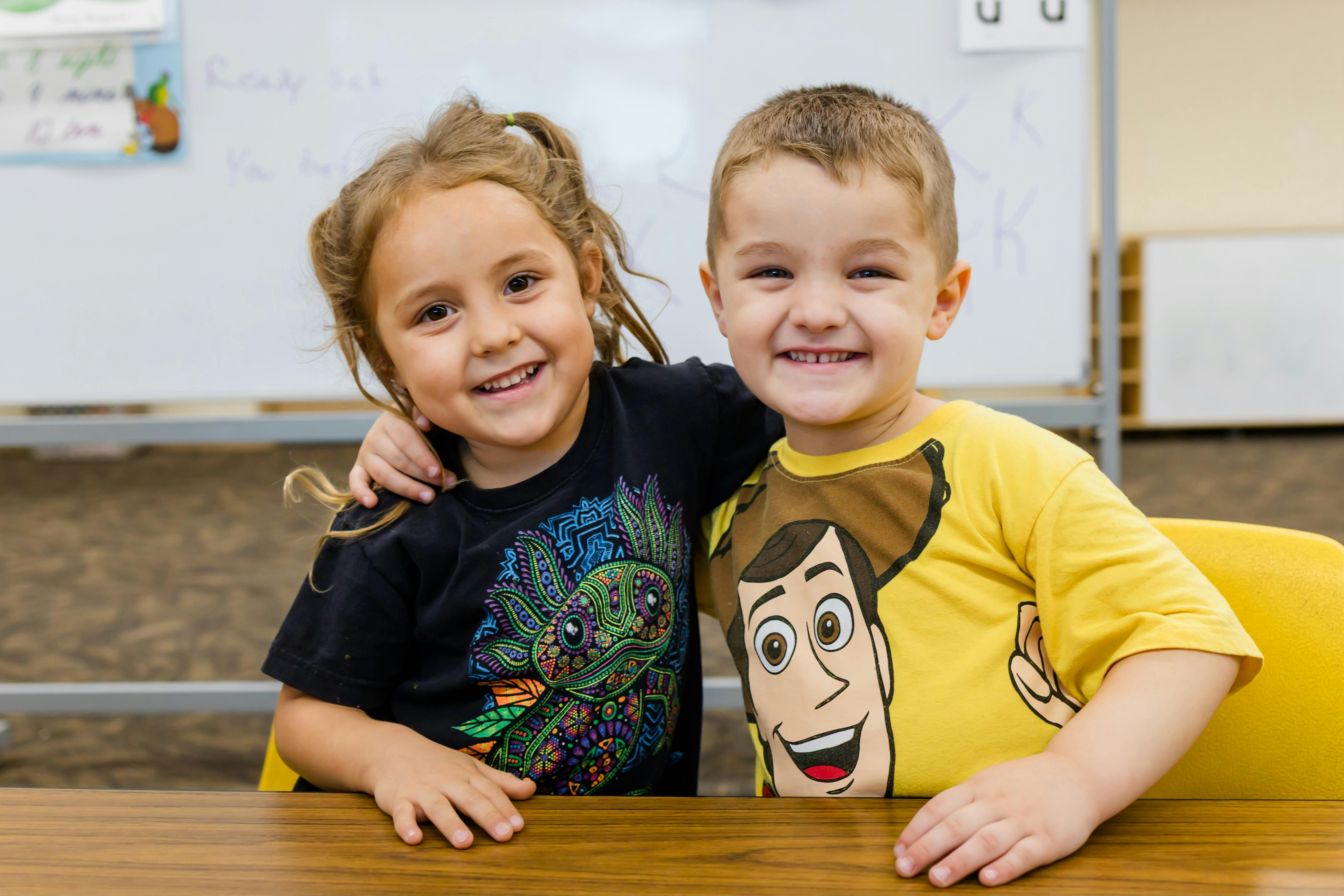 Two children smiling at a table