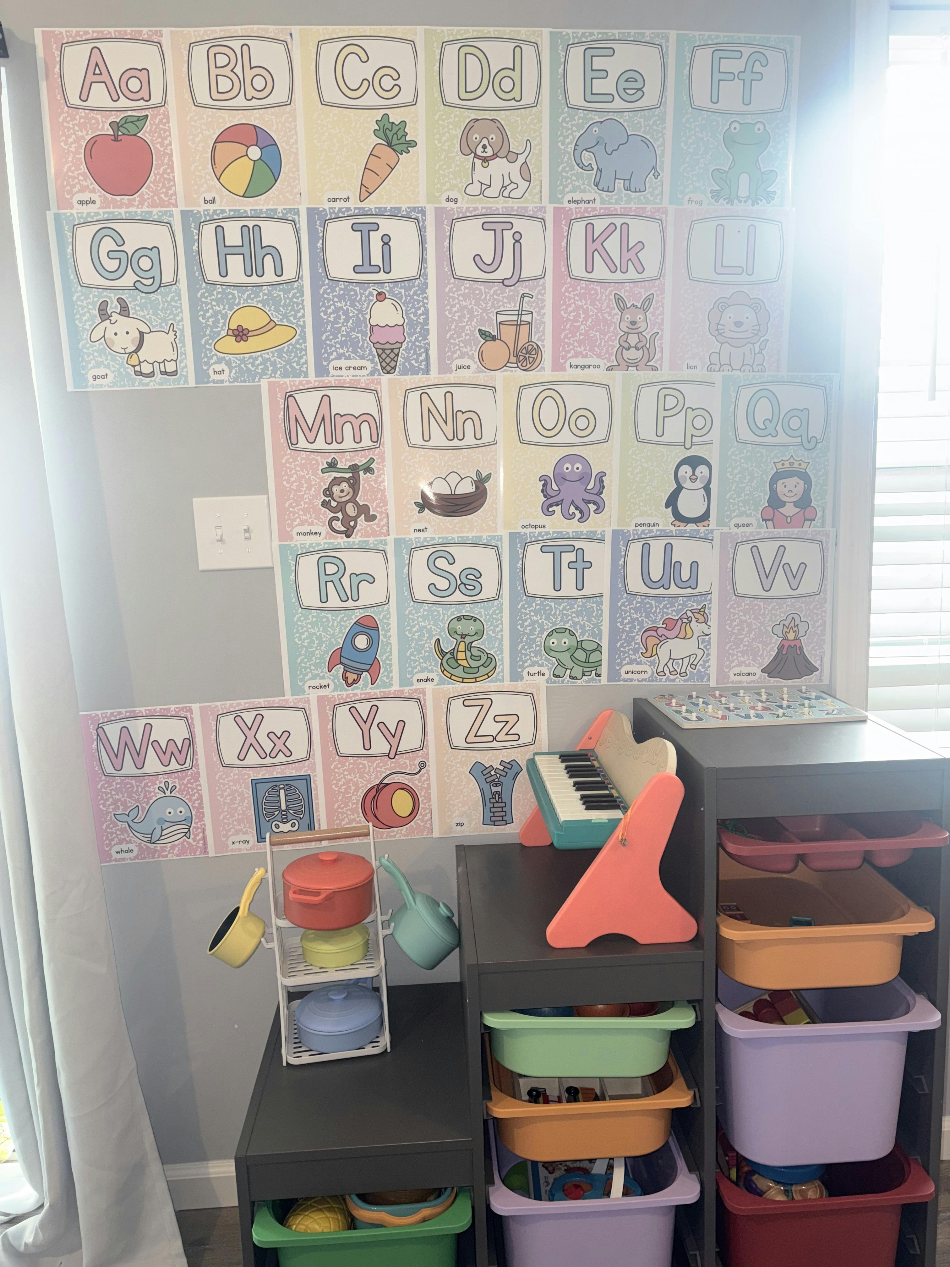 Alphabet wall posters with illustrations in a play area with toy storage