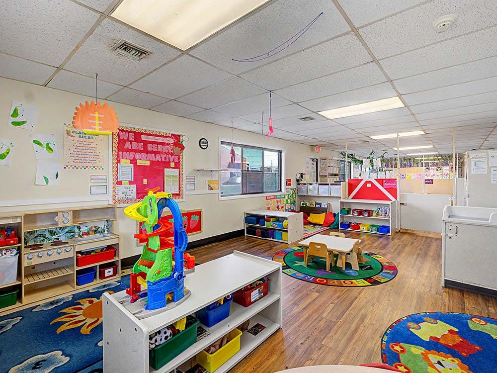 Colorful playroom in a daycare or classroom with various toys and rugs