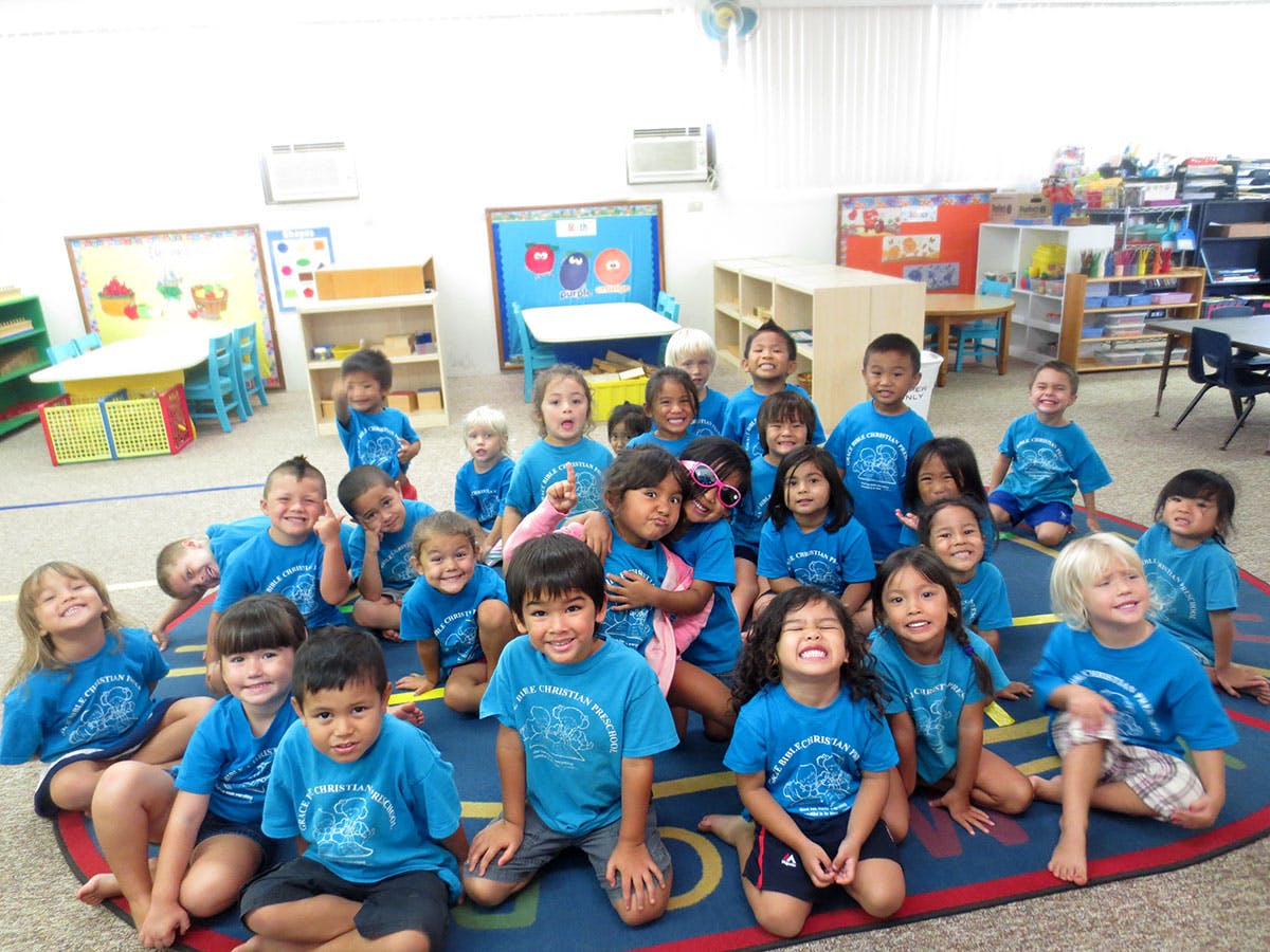 Group of children sitting on a rug in a classroom