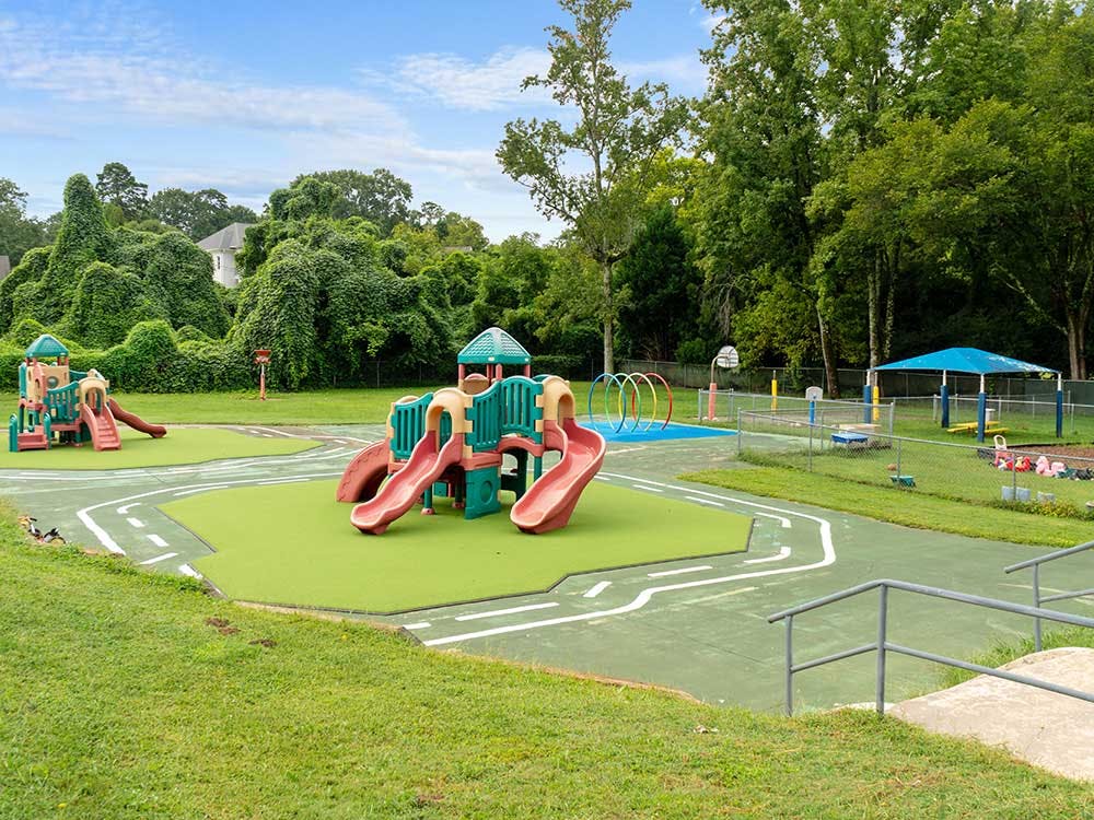 Outdoor playground with two play structures, slides, and a pathway