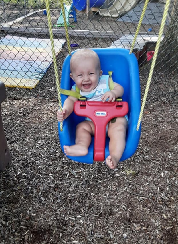 Child in a blue swing on a playground
