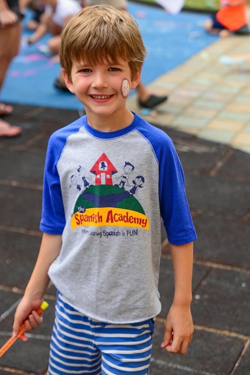 Child wearing a t-shirt with "The Spanish Academy" logo