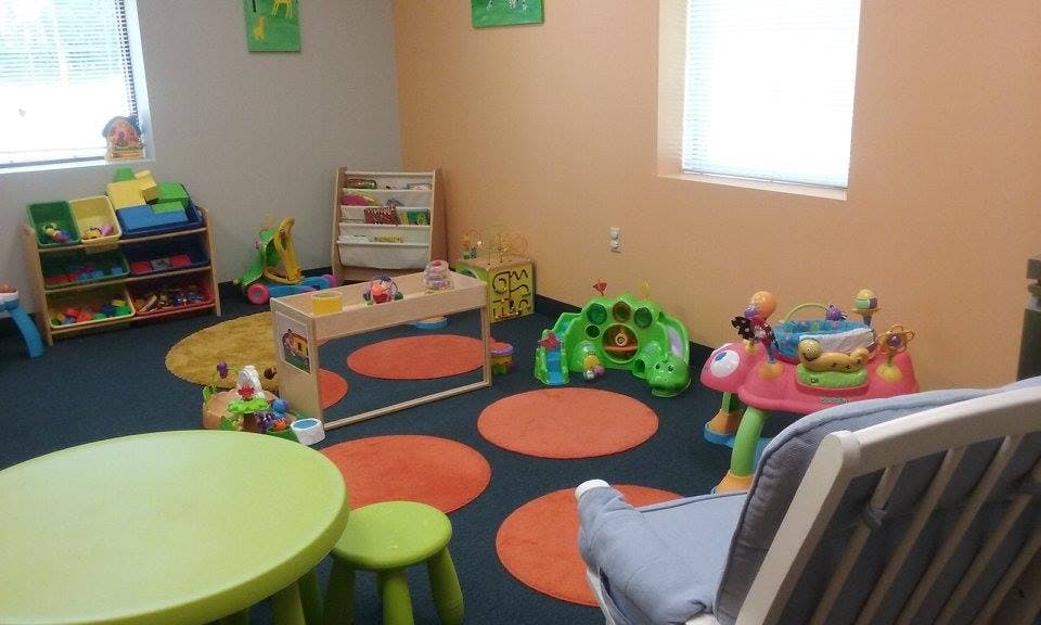 Playroom with toys, small tables, and chairs