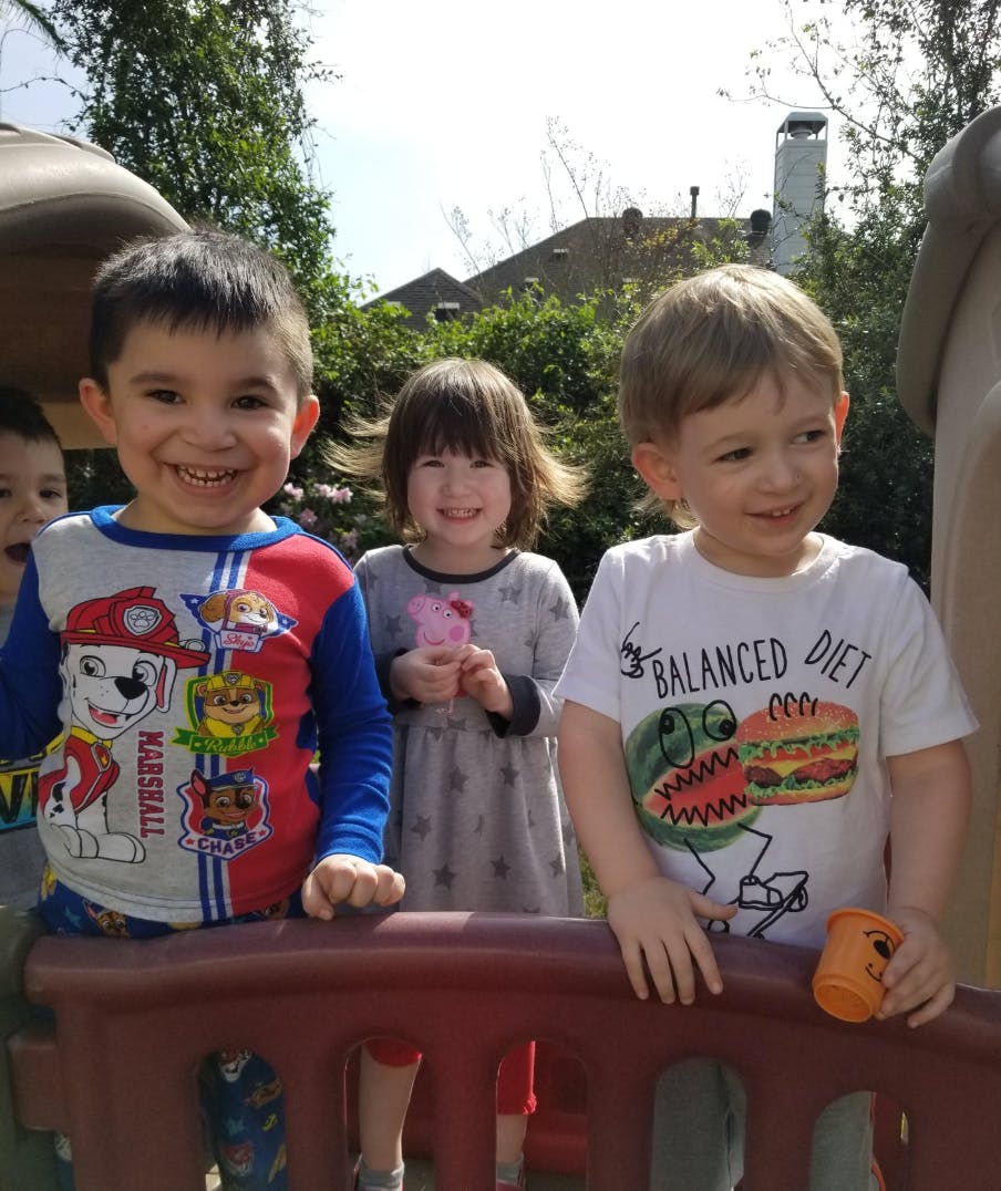 Three children smiling outdoors