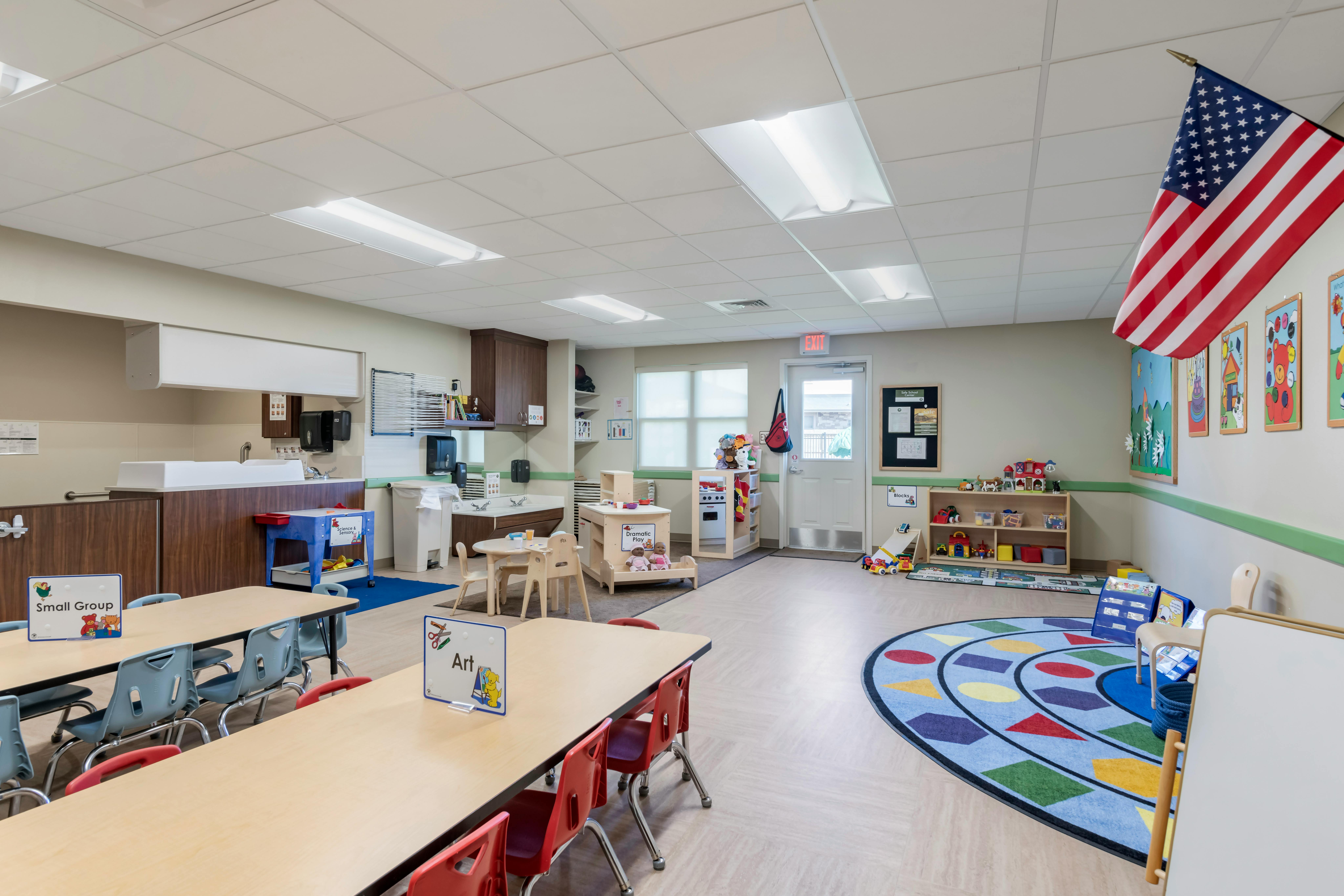Classroom with tables, chairs, and play areas for children