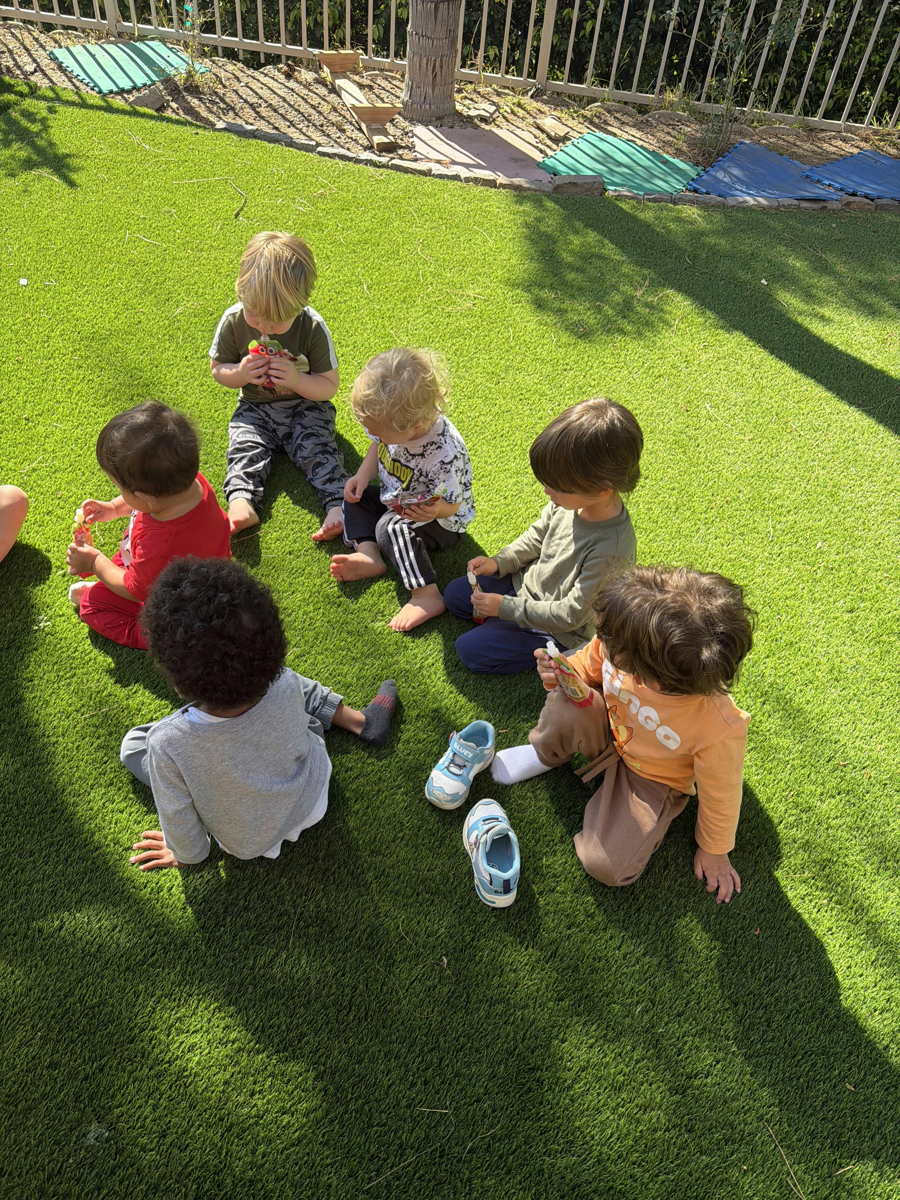 Children sitting on green grass
