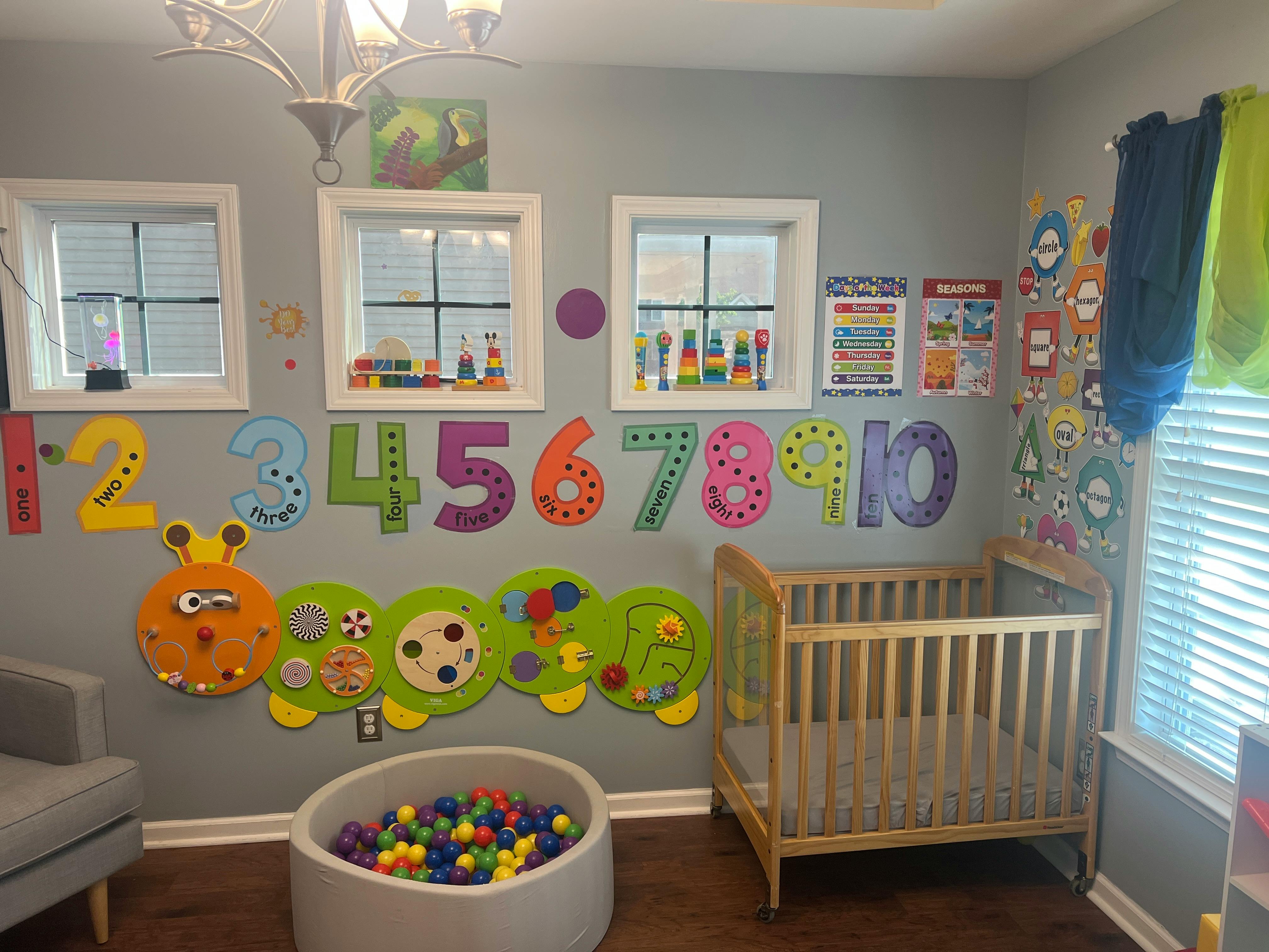 Child's room with a crib, ball pit, and colorful numbers on the wall
