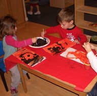 Two children painting at a table
