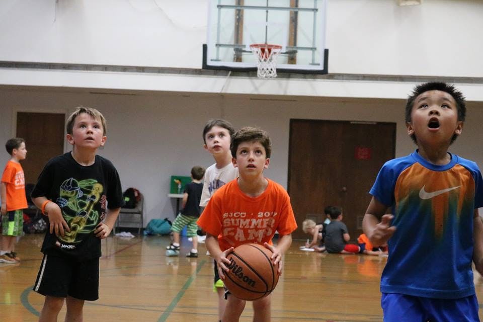 Children playing basketball in a gym