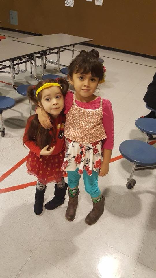 Two children standing together, one with an arm around the other