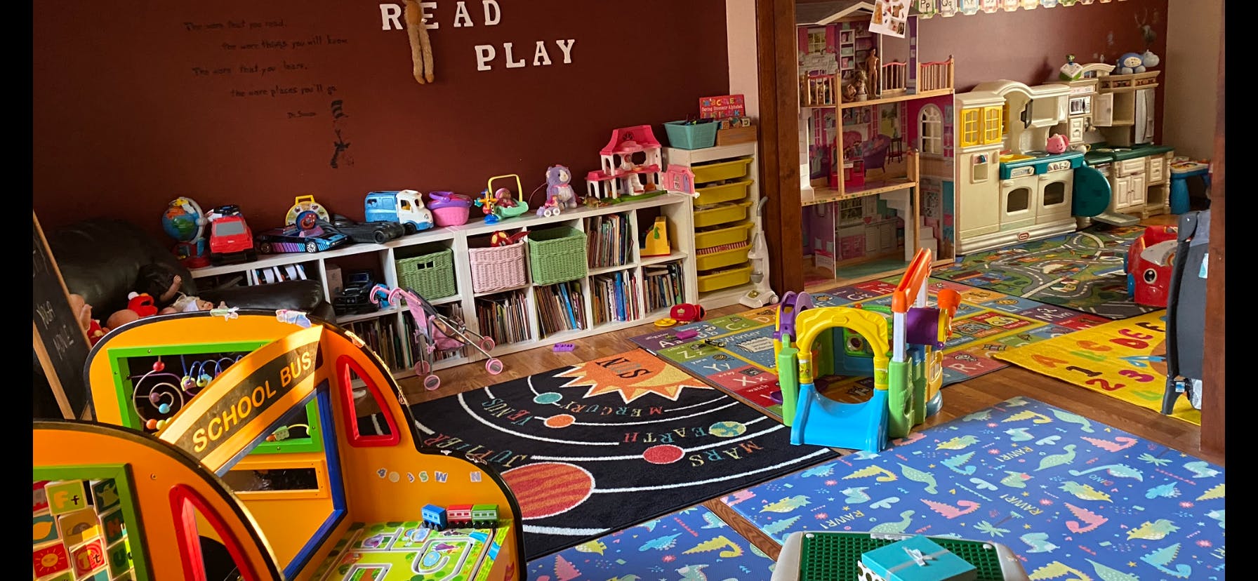 Children's play area with toys, bookshelves, and colorful rugs