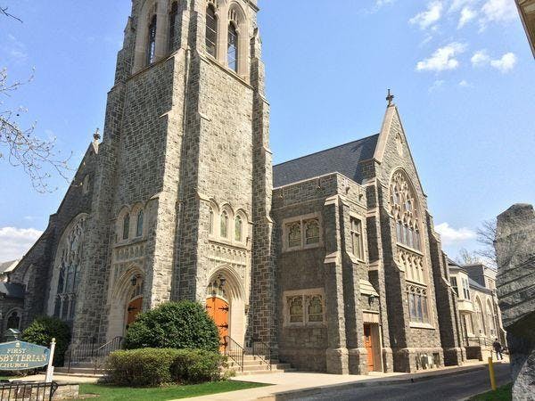 Stone church building with a tall bell tower and arched windows
