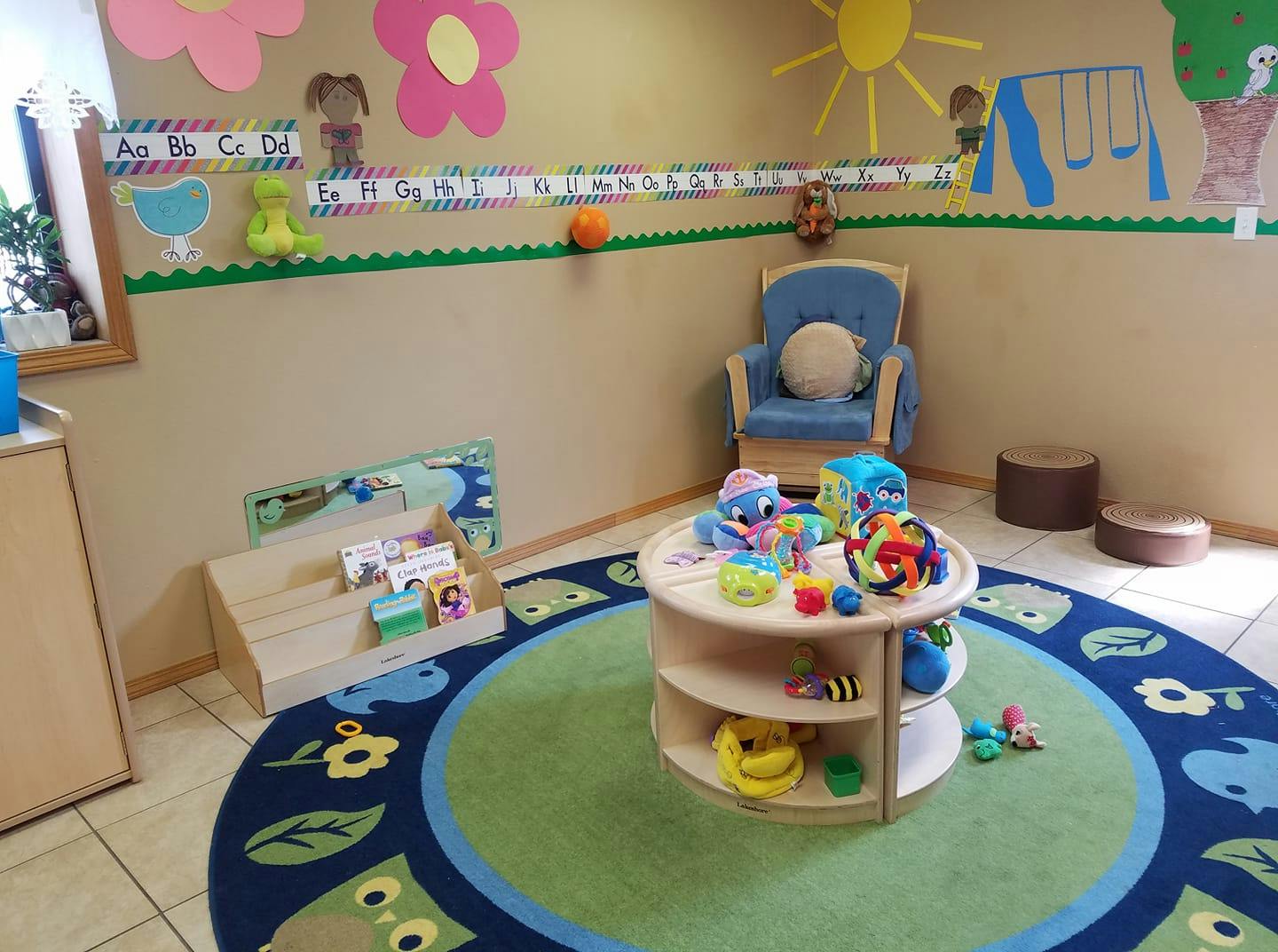 Playroom with a round rug, toy table, and alphabet decorations