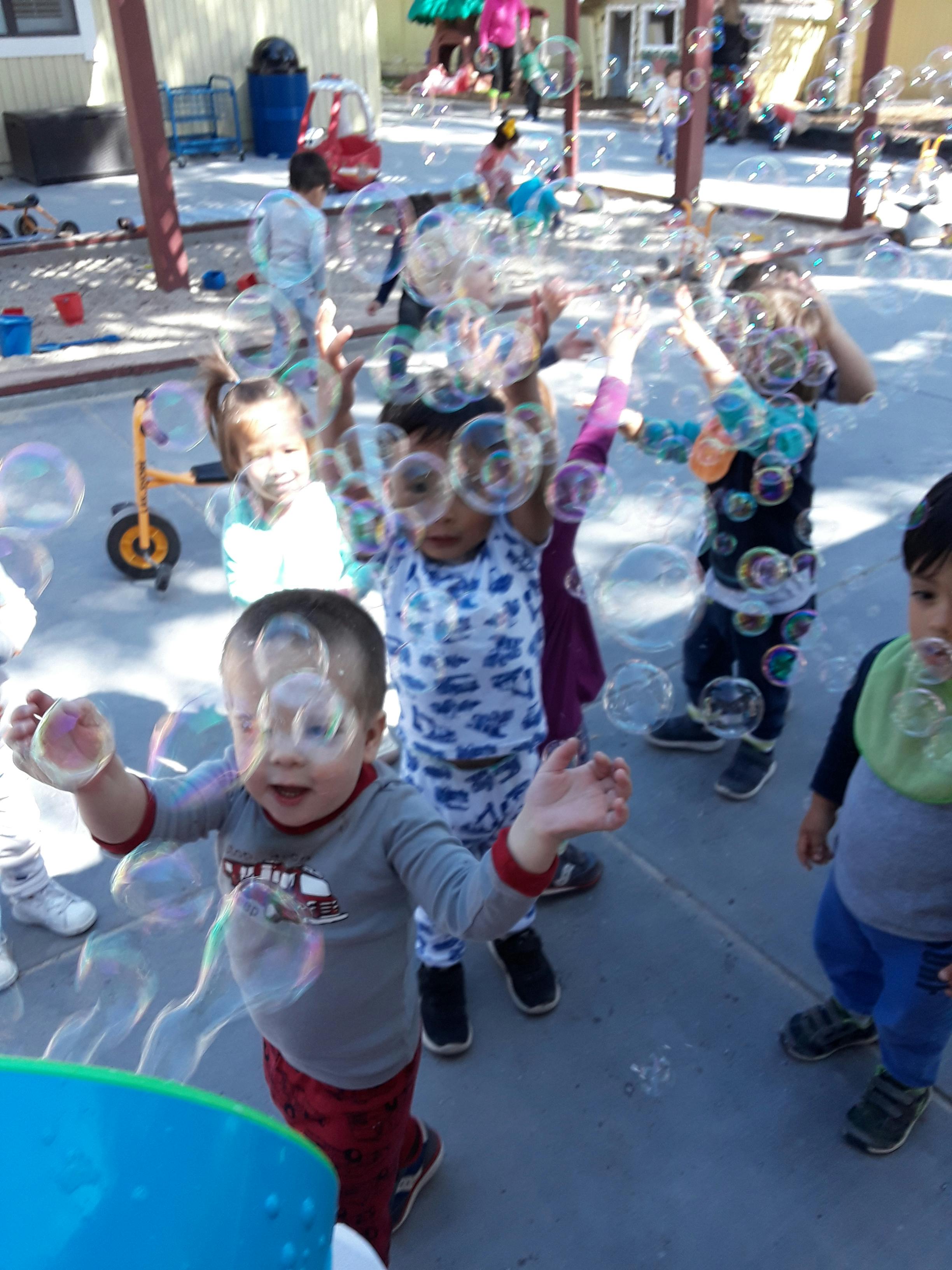 Children playing with bubbles outdoors