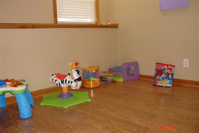 Playroom with various toys on a wooden floor