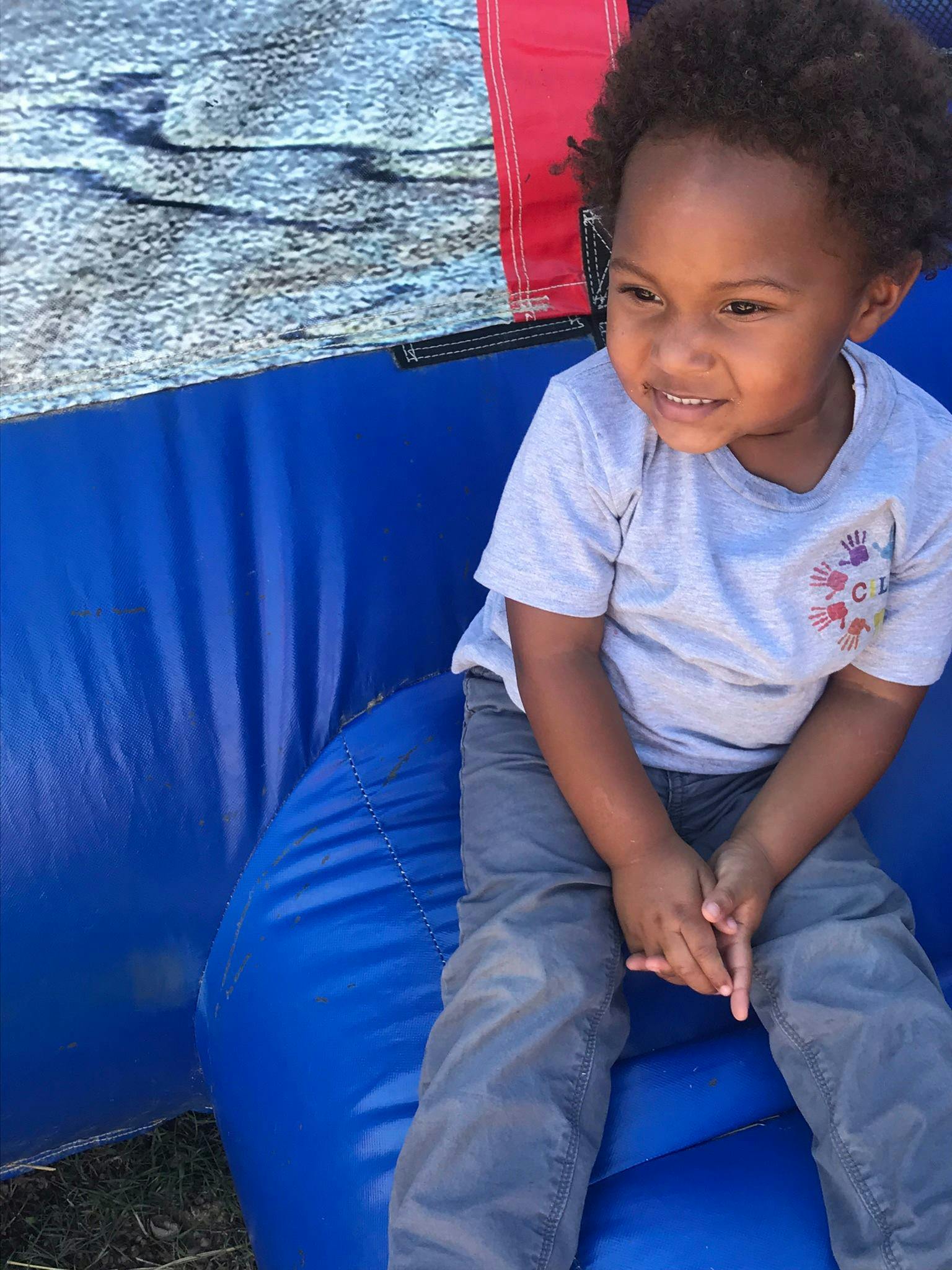 Child sitting on a blue inflatable surface