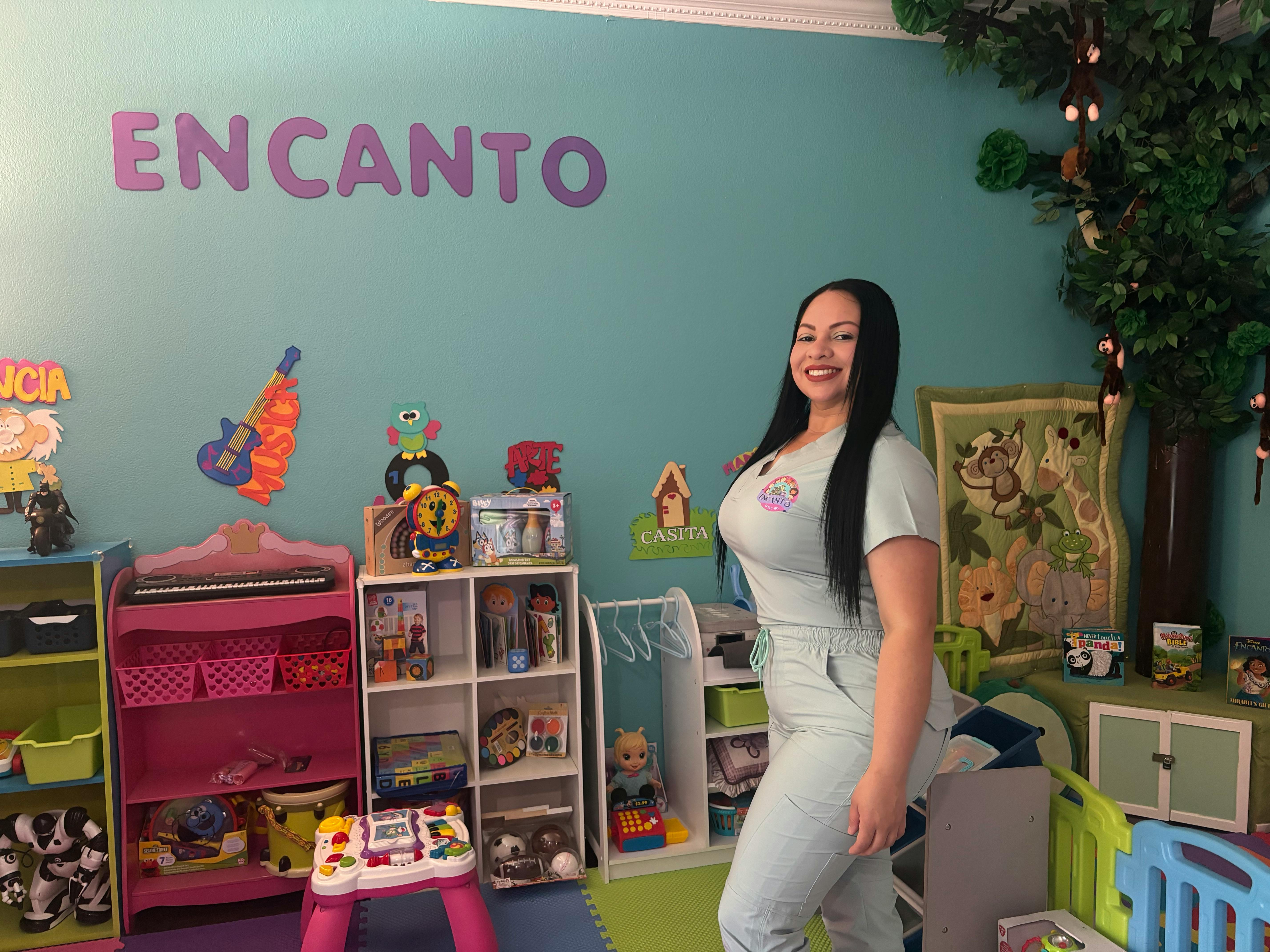 Person standing in a room with shelves of toys and the word ENCANT on the wall